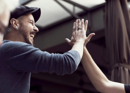 Zwei Männer machen Highfive Due uomini battono il cinque